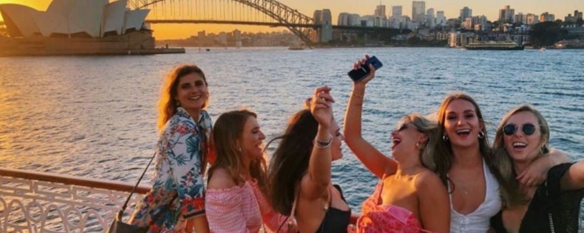 Happy group of girls on boat party in front of Sydney Opera House