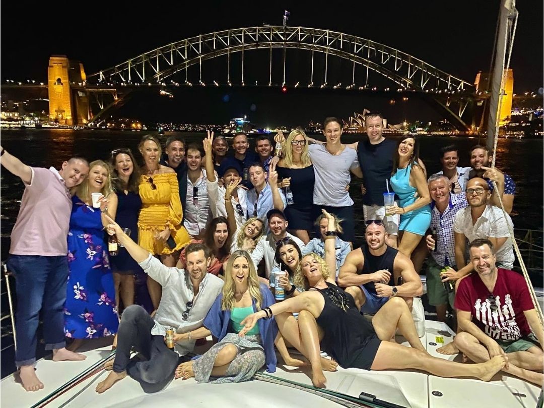 Evening boat party Sydney Harbour group photo in front of Sydney Harbour Bridge