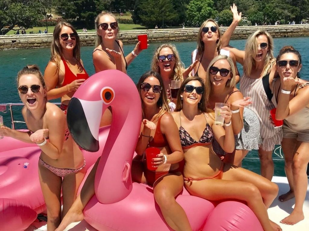 Girls on pink flamingo floaties private Sydney boat cruise